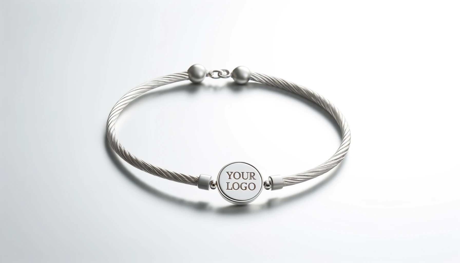 Silver cable bracelet with customizable logo medallion.